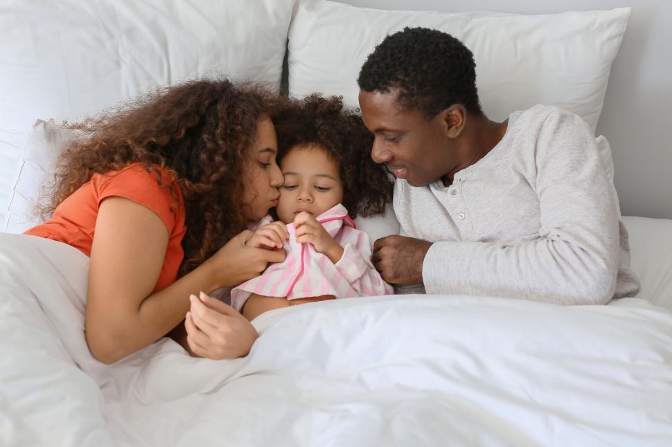 Parent showing affection by kissing their child.