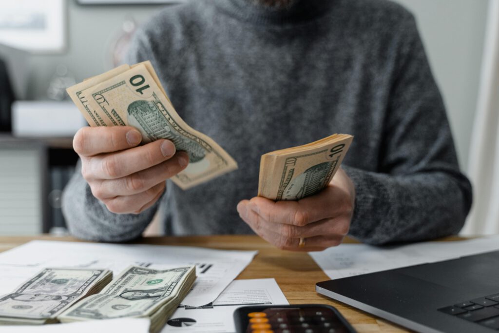 Man reviewing finances with money in hand