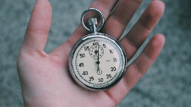 A pocket watch in a person's open hand. 